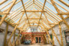 Dachstuhl aus Holz während der Bauphase mit sichtbaren Sparren und Betonwänden eines Neubaus